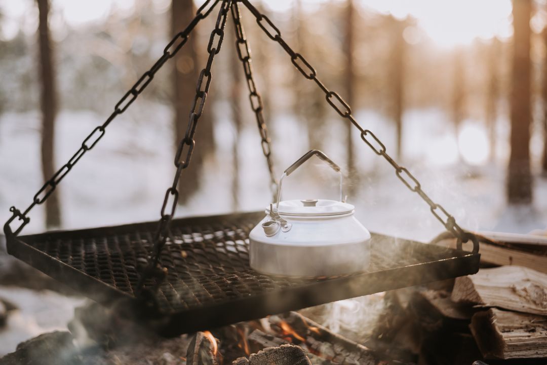 a camping kettle placed over a campfire