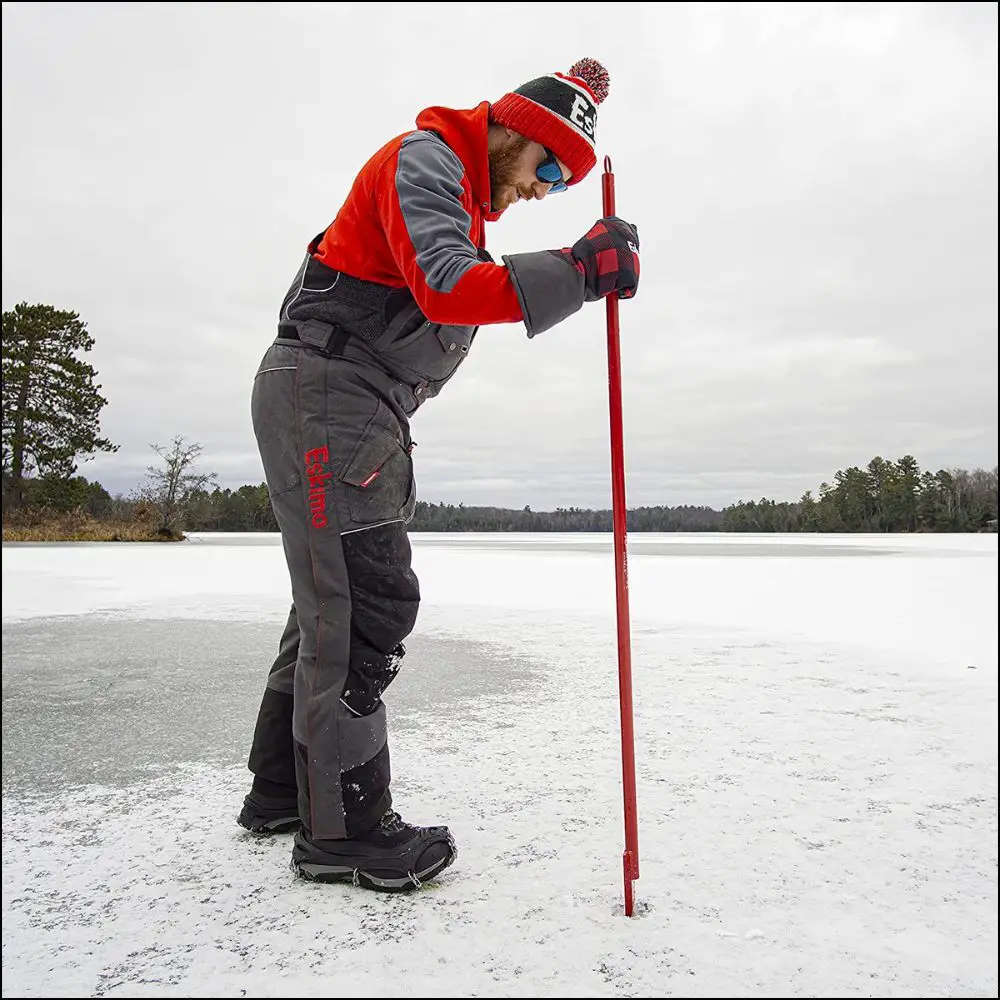 An ice angler using an ice axe 